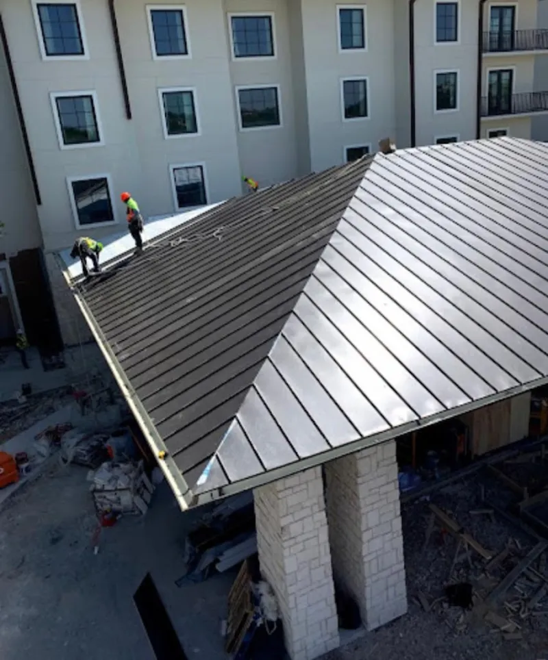 Crew installing standing seam metal roof panels on a commercial project in Fairfield Glade